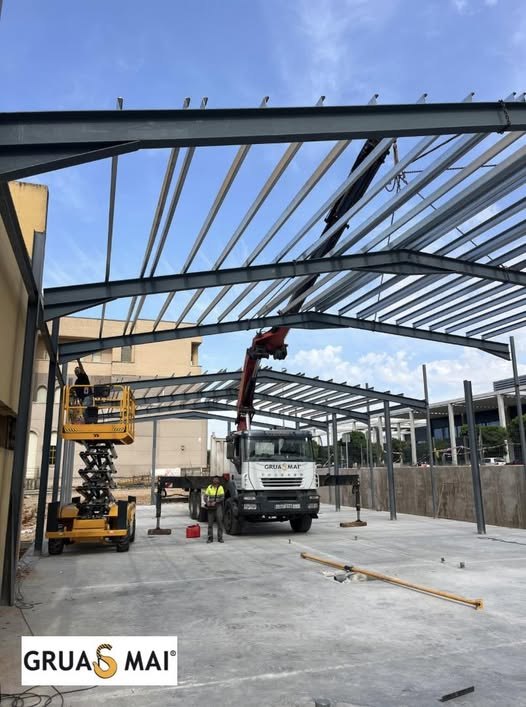 Camión pluma PK 44.002 y plataforma elevadora Compact 12DX de Grúas MAI colocando una estructura metálica en la Facultad de Medicina de Badajoz