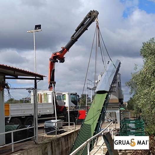 Camión pluma de Grúas MAI colocando una cinta transportadora en el término municipal de Badajoz